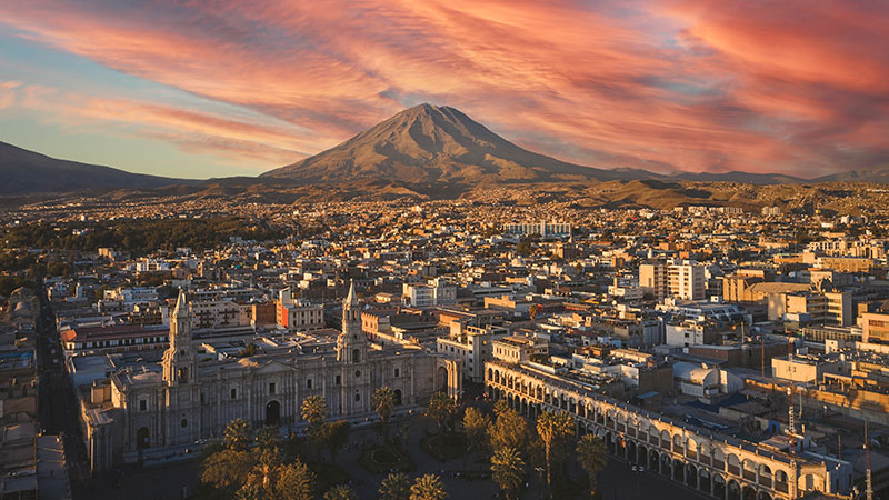 Aerial drone view of Arequipa main square and cathedral church, with the Misti volcano at sunset. Arequipa, Peru.